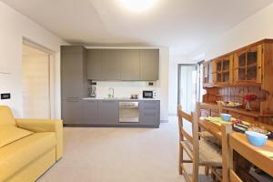 a kitchen and living room with a couch and a table at Casa Didi & Rosi - Lake Como in Colico