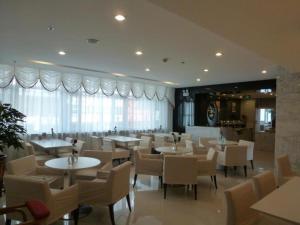 un restaurant avec des tables et des chaises et une grande fenêtre dans l'établissement Jinjiang Inn Tonghua Shengli Road Branch, à Tonghua