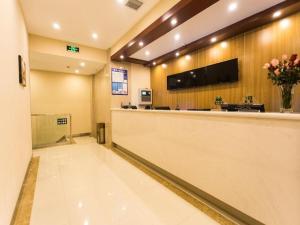 a hotel lobby with a reception counter and flowers at GreenTree Inn Suzhou Guanqian Street Leqiao Metro Station in Suzhou