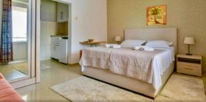 a bedroom with a large bed with towels on it at Apartments Kentera LUX in Sveti Stefan