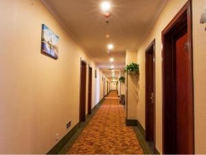 un corridoio con un lungo corridoio con una lunga corridorngthngthngthngthngthngthngthngthngthngth di GreenTree Inn Beijing Daxing District Yufa Town New Airport Express Hotel a Pechino