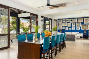 a dining room with a table and blue chairs at Parangi Weligama Bay - Thema Collection in Weligama