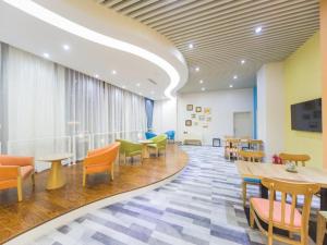 une salle d'attente avec des chaises et des tables colorées dans un hôpital dans l'établissement Gtel Rock City Qingdao Hotel, à Laoshan