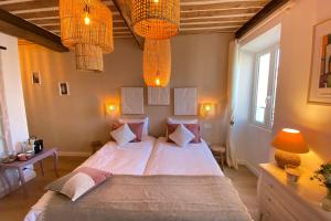 una camera da letto con un letto grande con lenzuola e cuscini bianchi di La Sanverine private room historic center Vence a Vence