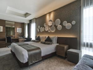 a bedroom with a large bed and a desk at The Strings Hotel Nagoya in Nagoya