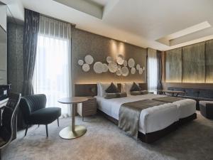 a hotel room with a king sized bed and a desk at The Strings Hotel Nagoya in Nagoya