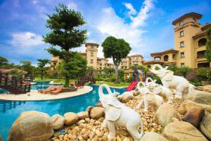 a group of white animals on rocks near a pool at Hainan Yatai Hot Spring Hotel in Haikou