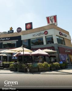 restauracja z parasolami przed budynkiem w obiekcie Alexandria Smouha Green Plaza Gateway,50 m from Green Plaza mall w Aleksandrii