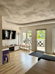 a living room with a coffered ceiling and a tv at Villa Blue Sky in Heinkensand