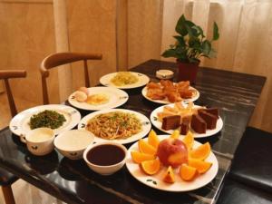 a table with plates of food on top of it at GreenTree Inn Jiangxi Shangrao Qianshan Ehu Avenue Express Hotel in Shangrao