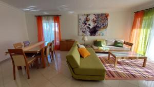 Una sala de estar con un sofá verde y una mesa. en Vilamoura TOP MouraPraia, en Vilamoura