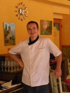 Człowiek stoi w restauracji z rękami w obiekcie Retour Aux Sources w mieście Meyras