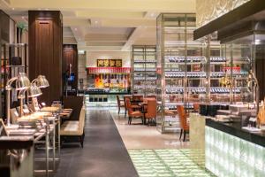 a restaurant with tables and chairs and a bar at Grand Bay Hotel Beijing in Xiaotangzhuang