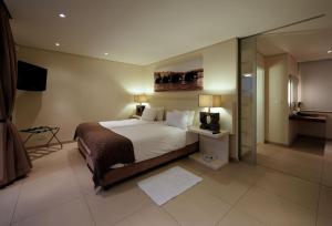 a bedroom with a large bed and a television in it at 129 on Kloof Nek Apartments in Cape Town +19 photos