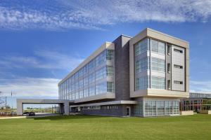 ein großes Bürogebäude mit einer Rasenfläche in der Unterkunft THE HOTEL AT KIRKWOOD CENTER in Cedar Rapids