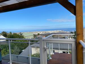 a balcony with a view of the ocean at Location saisonnière A portée de vue in La Possession
