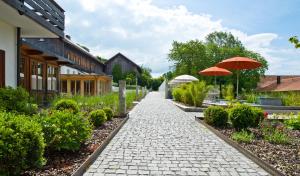 einen Steinweg mit Sonnenschirmen im Garten in der Unterkunft Biohotel Pausnhof in Sankt Oswald