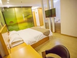 une chambre d'hôpital avec un lit, une table et une chaise dans l'établissement Vatica Beijing Miyun West Guoyuan Street Hotel, à Xiaotangzhuang