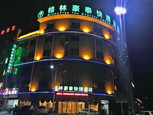 a building with neon signs on top of it at GreenTree Inn Ningbo Ninghai Beidou North Road Express Hotel in Shang-ts'un