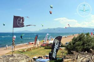 a beach with many kites flying in the sky at Silver Coast Cottage Raches in Kouvéla +38 photos