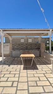 a picnic table sitting on top of a patio at Perla Bianca in Marina di Lizzano +17 photos