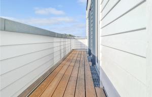 einen Balkon eines Hauses mit einer Holzterrasse in der Unterkunft Amazing Home In Tossens With Wifi in Tossenserdeich