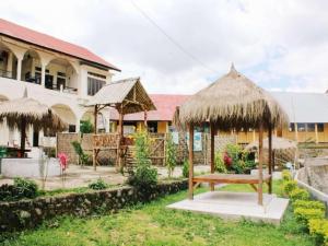 een resort met een bankje en een gebouw bij FX 72 Ruteng Hotel in Ruteng