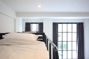 a bedroom with two beds and a window at L22 HOSTEL in Bangkok