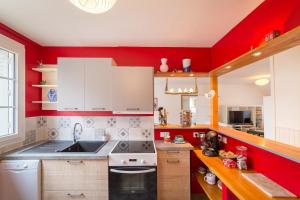 a red kitchen with a sink and a stove at L'Averia - Appartement spacieux en hypercentre in Blois +9 photos