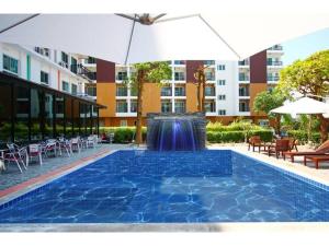 a swimming pool with an umbrella and a fountain at Royal King Suite in Ban Khlong Sanam Phli
