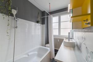 a bathroom with a tub and a sink at L'Averia - Appartement spacieux en hypercentre in Blois