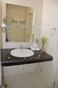 bagno con lavandino e specchio di Peace Inn Chennai a Chennai