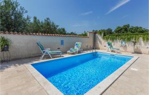 FondoleにあるNice Apartment In Fondole With Wifiの壁の隣に椅子2脚付きのスイミングプール