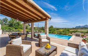 a patio with a table and chairs and a pool at Cozy Home In Puerto De Alcudia in Port d'Alcudia