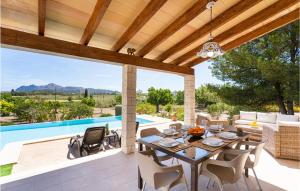 a patio with a table and chairs and a pool at Cozy Home In Puerto De Alcudia in Port d'Alcudia