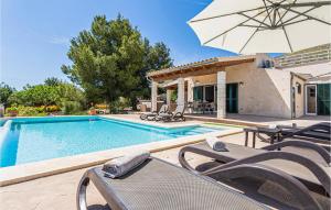 a swimming pool with chairs and an umbrella at Cozy Home In Puerto De Alcudia in Port d'Alcudia +35 photos