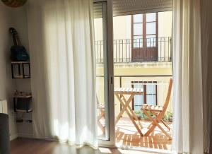 a sliding glass door with a chair on a balcony at Vacation house in the mountains in Esparraguera