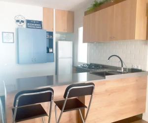 a kitchen with a counter with two chairs and a sink at Vacation house in the mountains in Esparraguera
