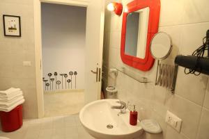 un bagno con un lavandino bianco e uno specchio di B&B La casa di Paola a Trapani Altre 65 foto