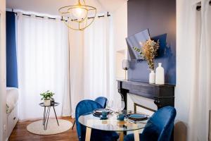 une salle à manger avec des chaises bleues, une table et un piano dans l'établissement OIQIA • Jadéa • Saphir, à Bressuire