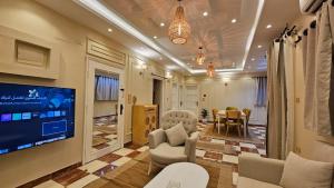 a living room with a tv and a dining room at Mansoura sweet home hotel apartments in Mansoura