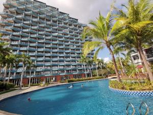a large apartment building with a swimming pool and palm trees at Kingreal seaview resort sanya in Sanya