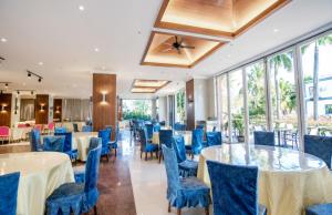a dining room with blue chairs and tables and windows at Kingreal seaview resort sanya in Sanya