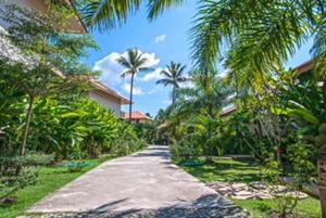 ein Gehweg mit Palmen und einem Gebäude und einer Straße in der Unterkunft Blue Koh Yao Yai Resort and Villa in Ko Yao Yai