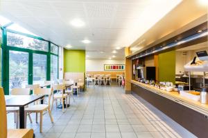 a dining room with tables and chairs in a restaurant at B&B HOTEL Orly Rungis Aéroport 2 étoiles in Rungis