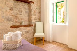 a living room with a chair and a window at LUXE Diocletian Stones Split Centre in Split
