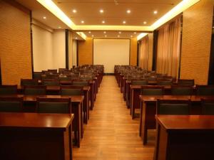 a lecture hall with wooden tables and chairs at GreenTree Inn Suzhou Yongqiao District Jinhai Avenue Branch in Suzhou