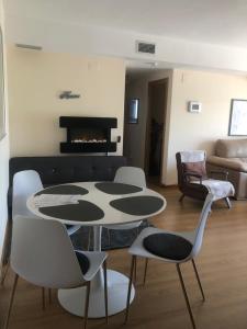 a living room with a table and chairs and a fireplace at Apartment Panoramica Golf in Sant Jordi