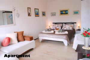 a bedroom with two beds and a white couch at Sunshower apartment and studio in Split