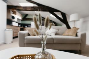 a vase with feathers in it on a table in a living room at OIQIA • Arthéa • Atelier in Périgueux +13 photos